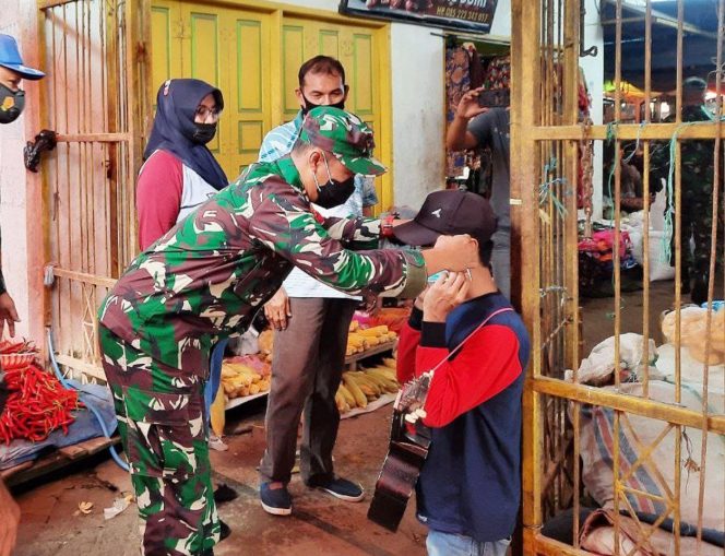 
 Dandim 1420 Sidrap, Letkol Inf Dodi Nur Hidayat memasang masker ke salah satu warga di Pasar.