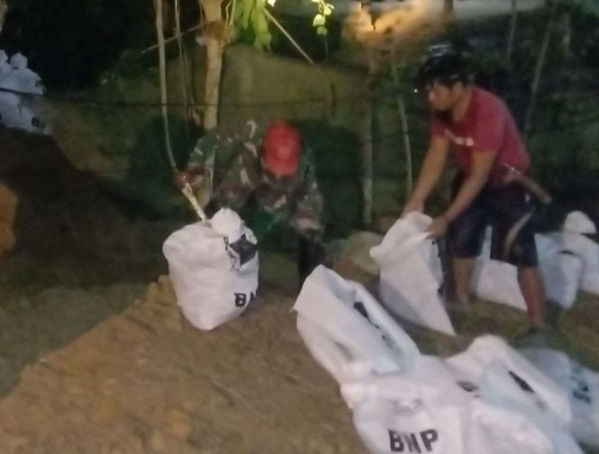 
 Personel TNI dari Kodim 1420 Sidrap turun tangan membantu warga mengantisipasi banjir akibat luapan air sungai di Tanru Tedong, Rabu (31/8/2022).